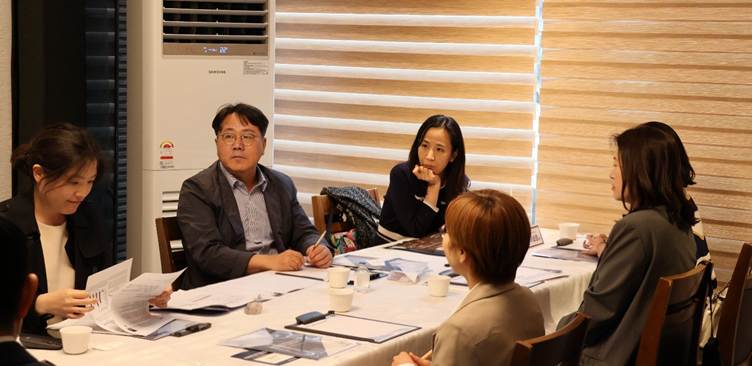 The image depicts a meeting room setting with a large table, documents, and people engaged in a discussion, with Samsung's logo visible on one of the documents.
AI 생성 콘텐츠는 정확하지 않을 수 있습니다.